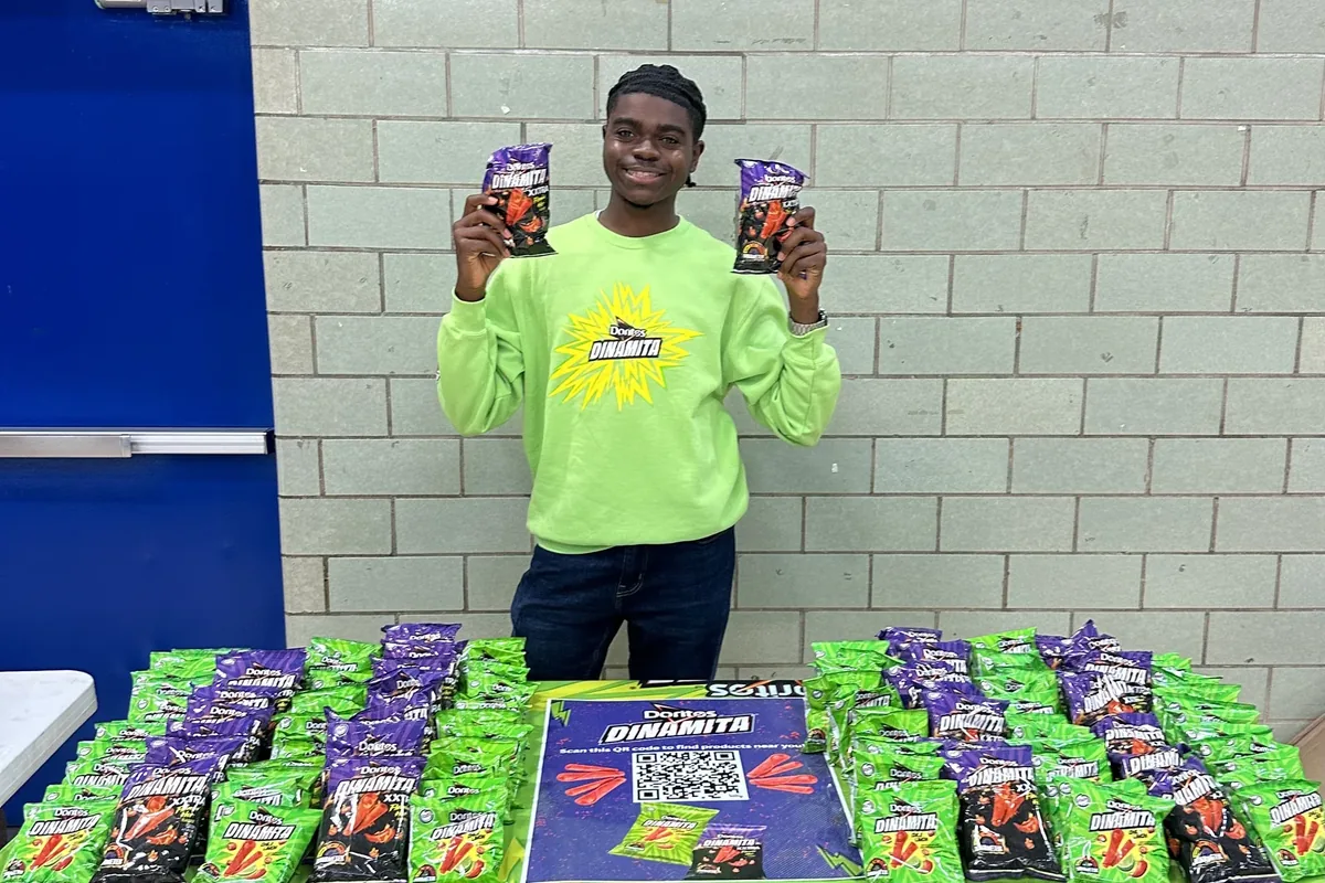 A college Brand Ambassador running a campus sampling event with visible product display